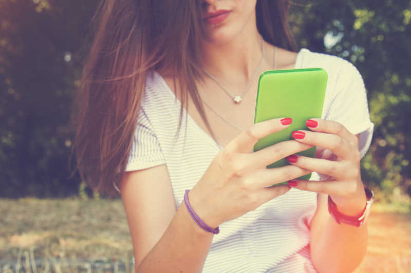 年轻女人在户外玩手机
