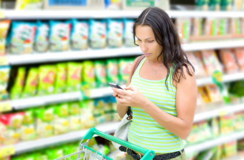 在超市购物的女子使用手机