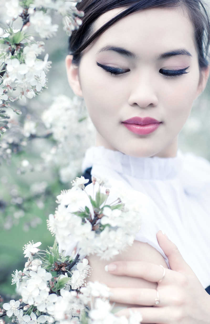 白色樱花旁的年轻女子
