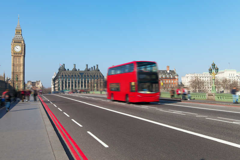 伦敦威斯敏斯特大桥上行驶的红色双层公共汽车
