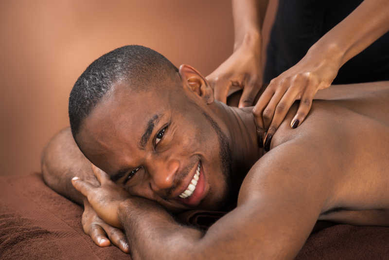 年轻的非洲男子正微笑着享受按摩
