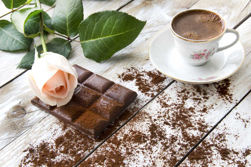 土耳其咖啡桃色玫瑰以及木桌上的巧克力片