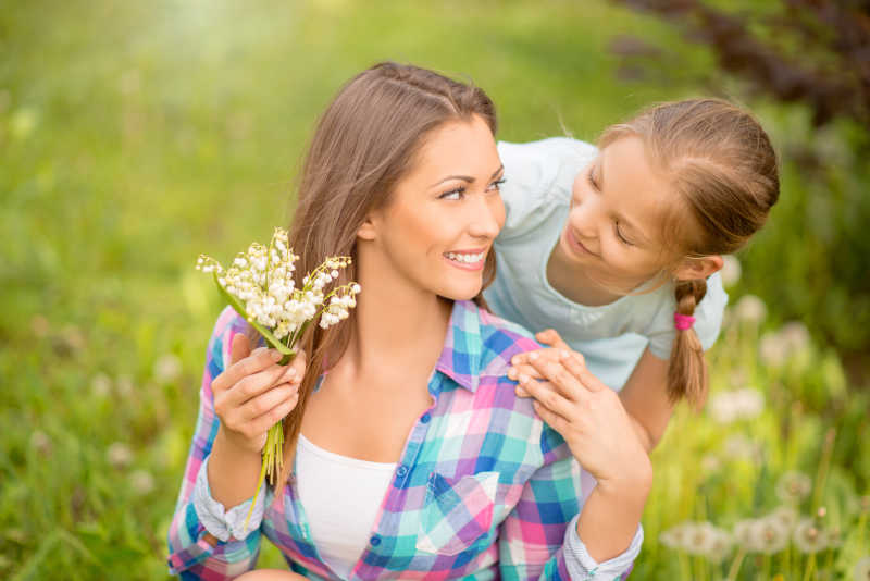 可爱的女儿在公园给妈妈送花