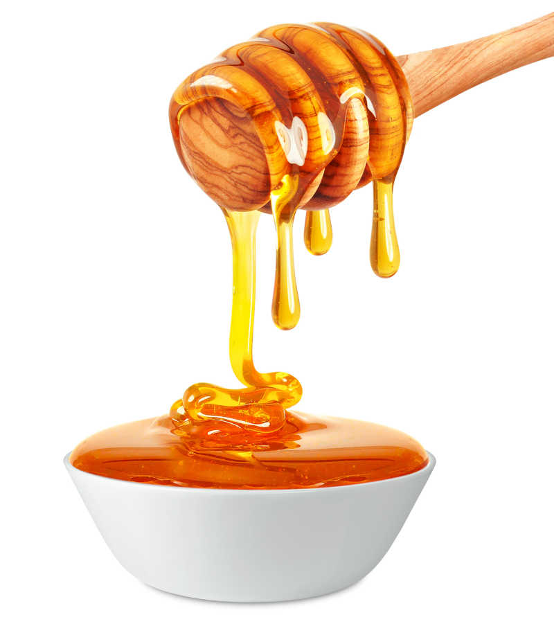 蜂蜜从木棒上滴入下面的碗里