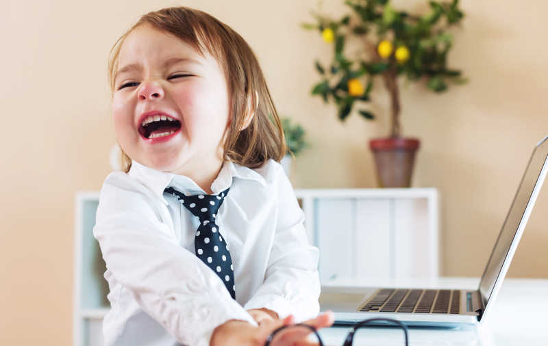电脑前开心大笑的婴儿小商人