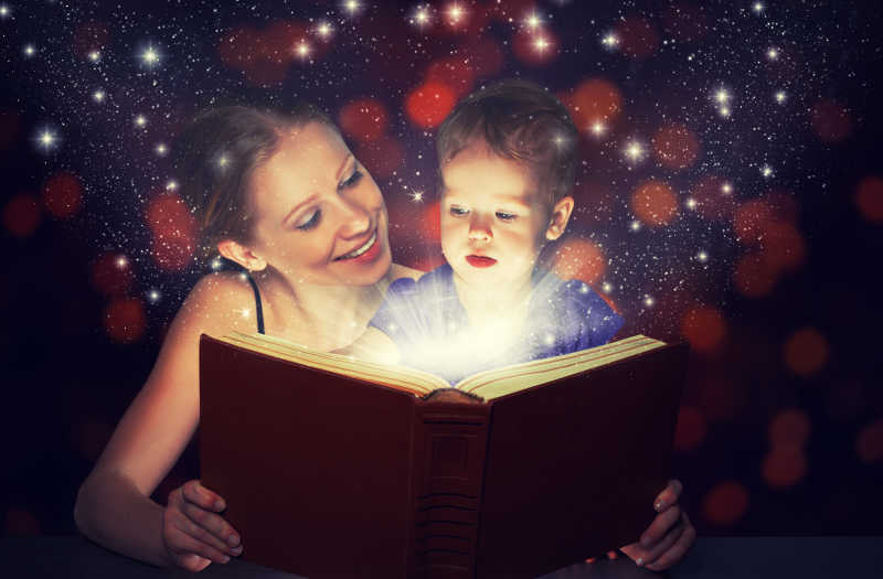 家庭母婴宝贝女儿在黑暗中阅读魔法书
