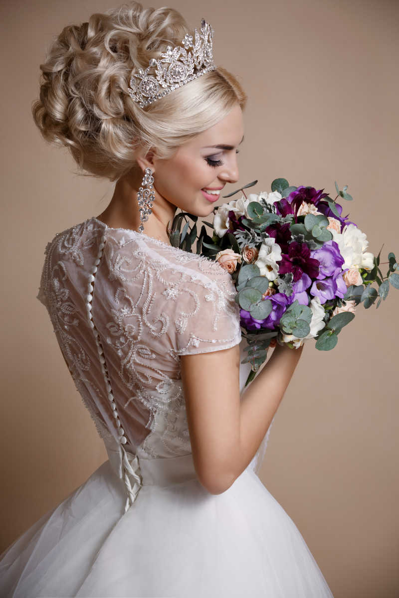 穿着漂亮婚纱的新娘手里拿着一束漂亮的鲜花