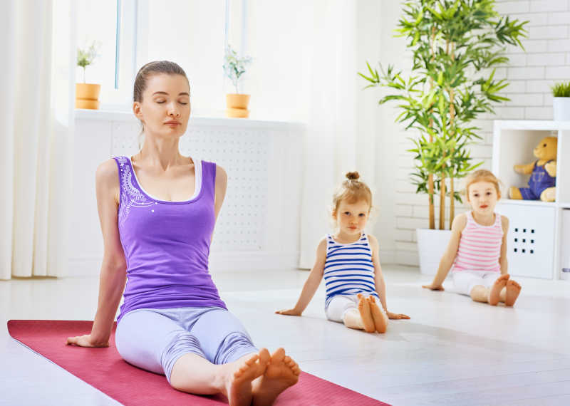 带着两个女儿练习瑜伽的年轻妈妈