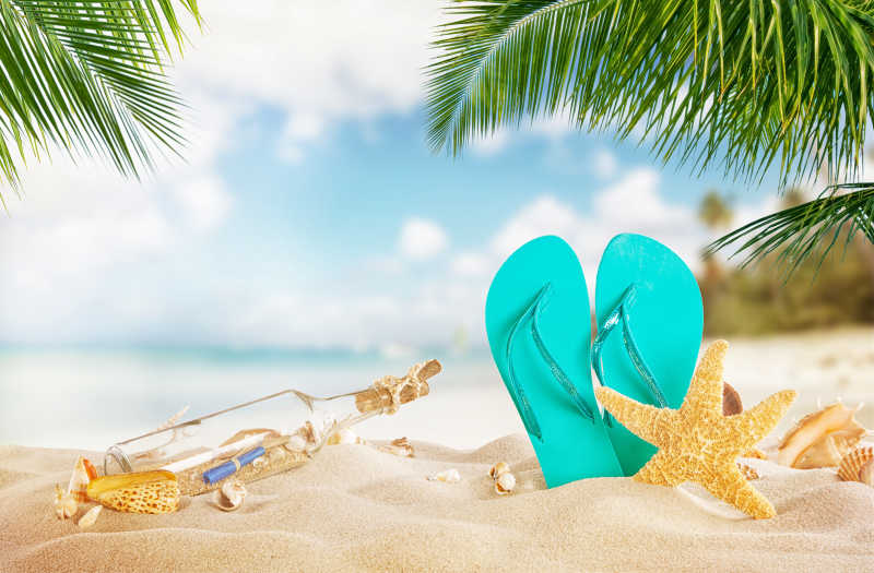 热带海滩上的凉鞋海星和漂流瓶