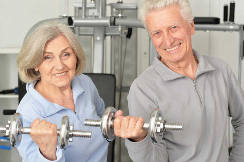 在健身房里锻炼的老年夫妇