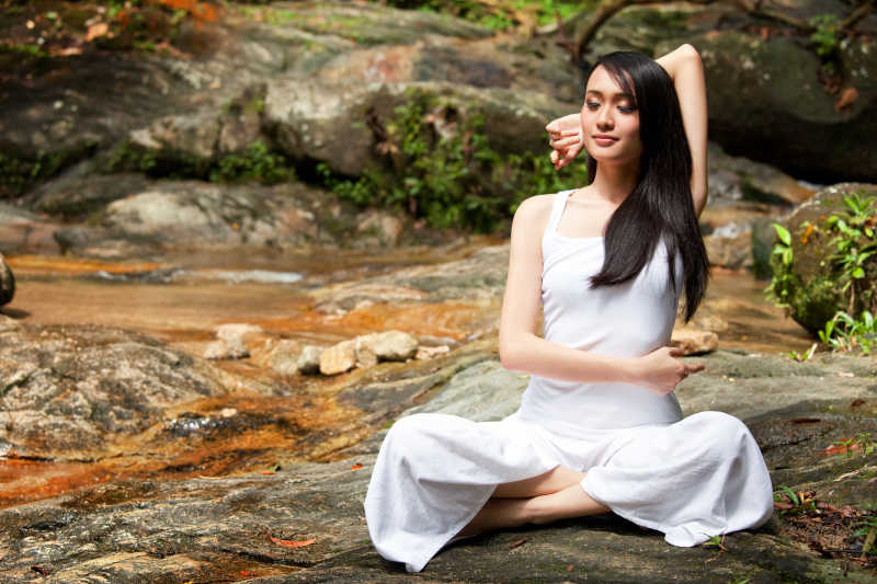 在美丽的户外天然林练习瑜伽的亚洲女子