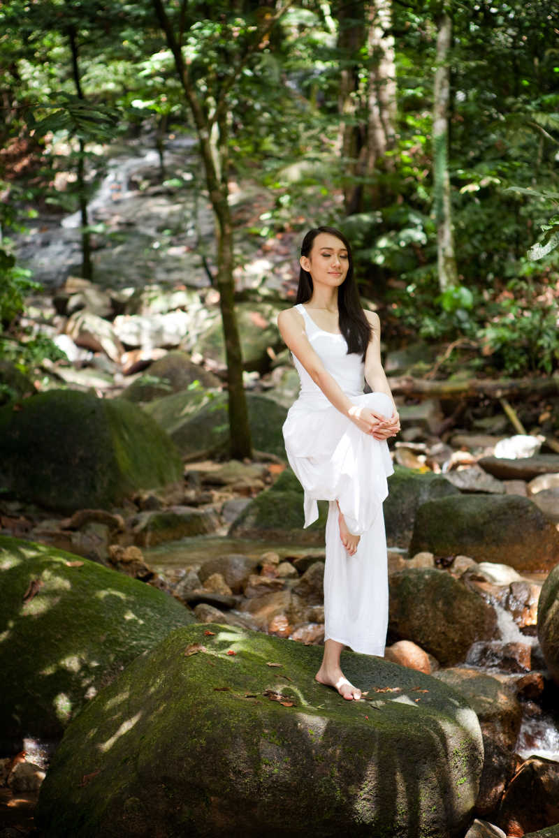 亚洲的美丽女子在户外天然林练习瑜伽