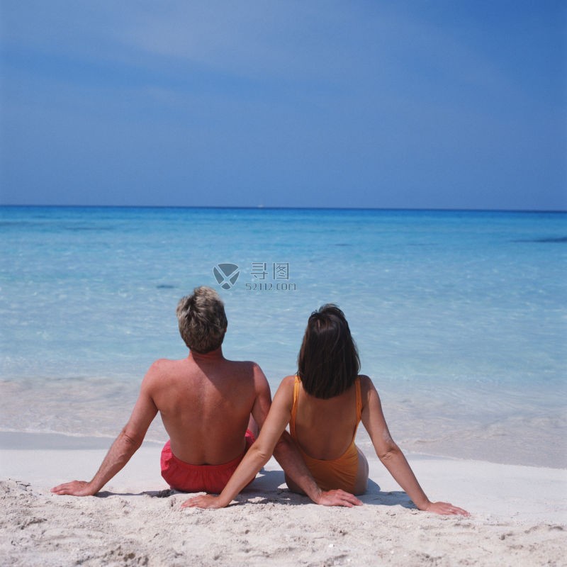 旅游中坐在海滩边放松的年轻情侣