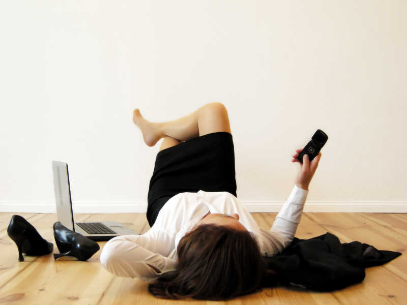 躺在地板上玩手机的女人