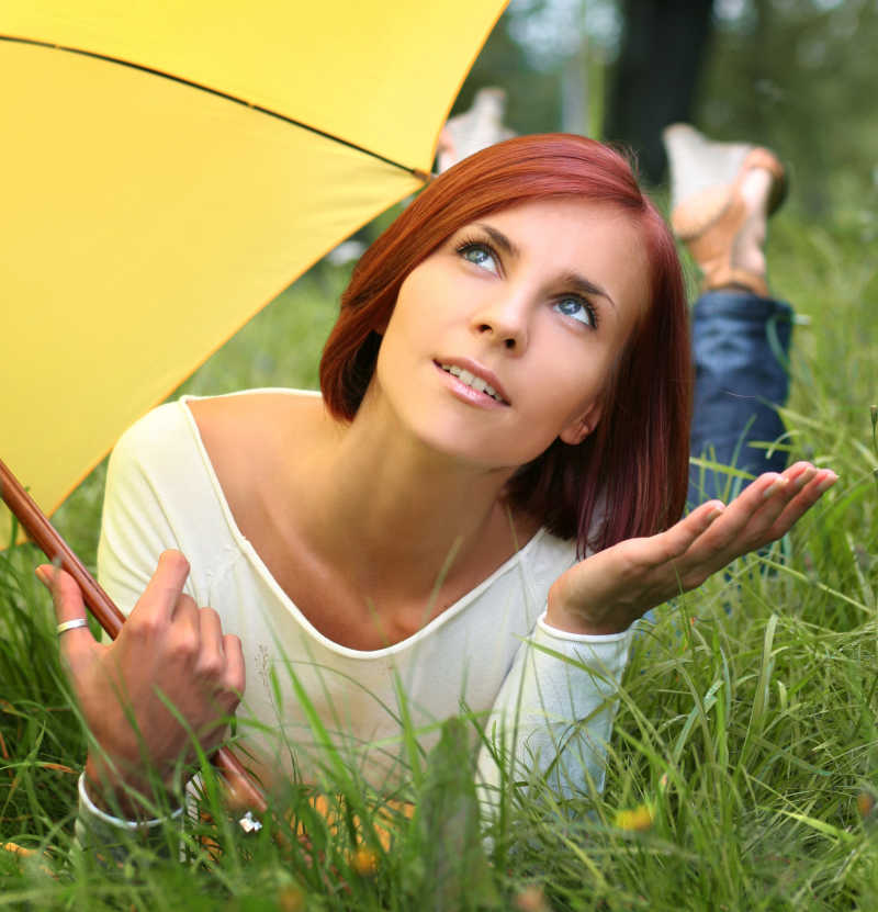 草地上撑着伞的女孩