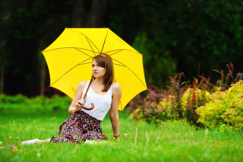 草地上撑着伞的美女