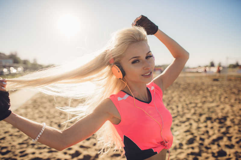 女孩在海滩上跑步听音乐