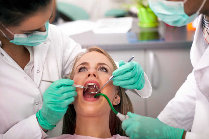 治疗女性患者的牙齿的牙科医生