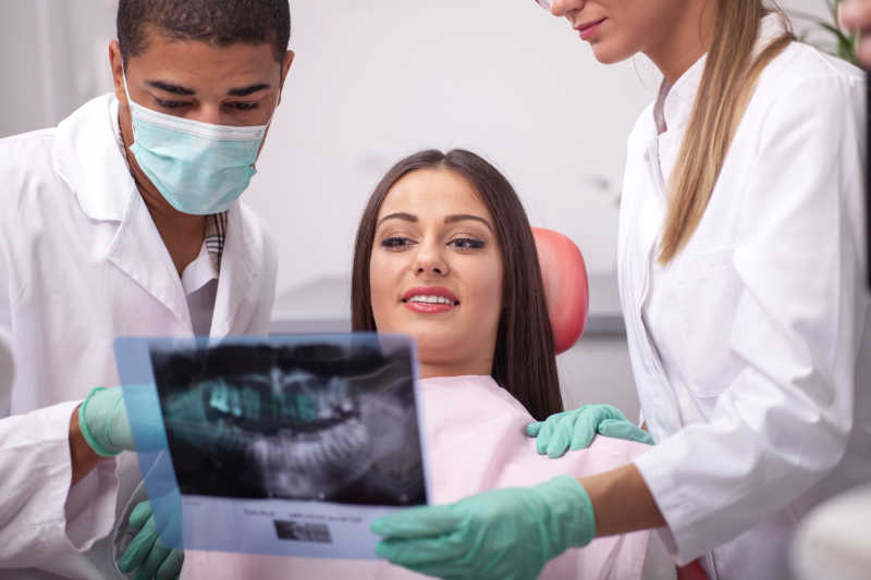 牙科医生和美女患者看X光图像
