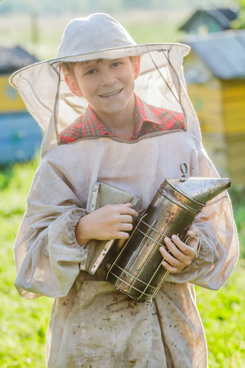 年轻的养蜂人在蜂场里检查蜂箱