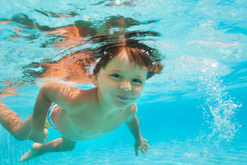 小男孩在水下游泳的特写镜头