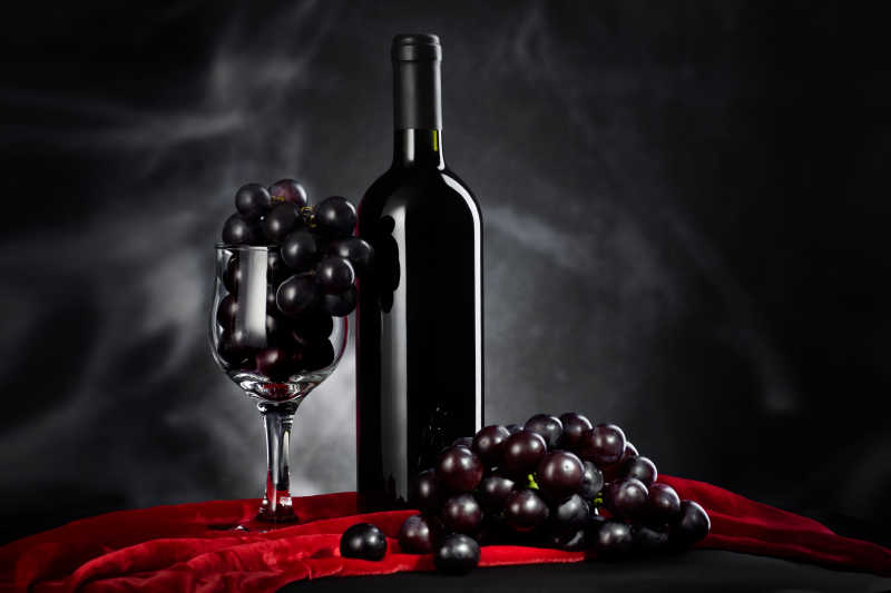 黑色背景上的葡萄与葡萄酒