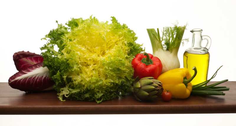 桌子上放满新鲜的蔬菜和食用油