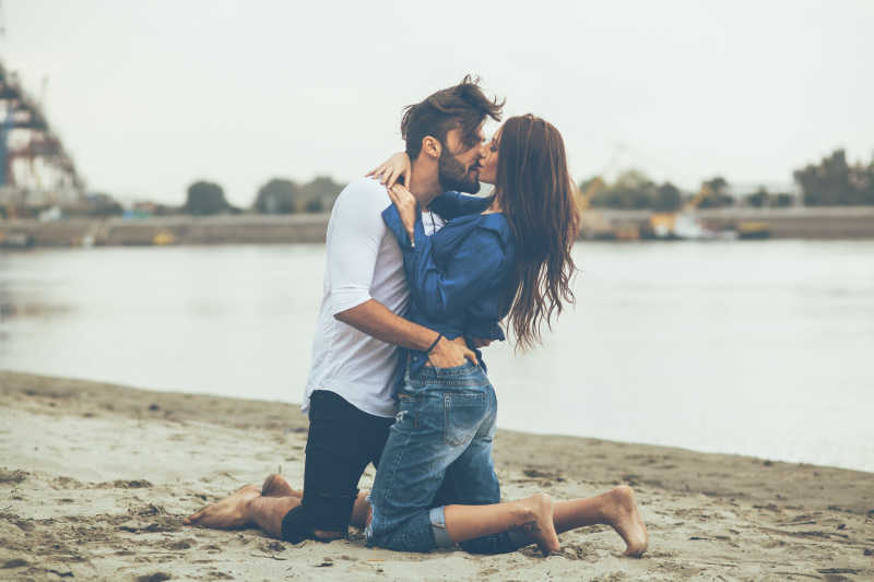 沙滩上接吻的年轻夫妇