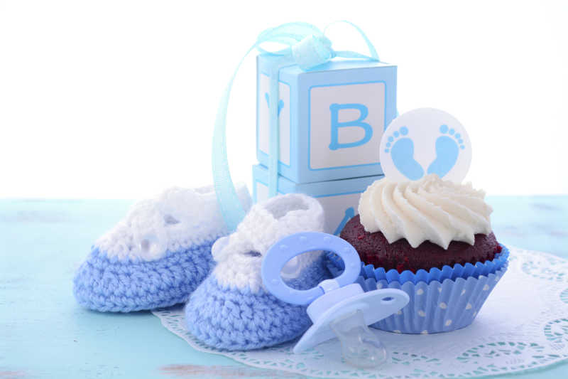 蓝色的婴儿的鞋和蛋糕