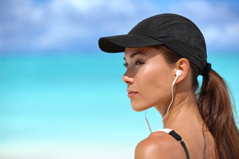 海滩上健身运动戴耳机的女孩