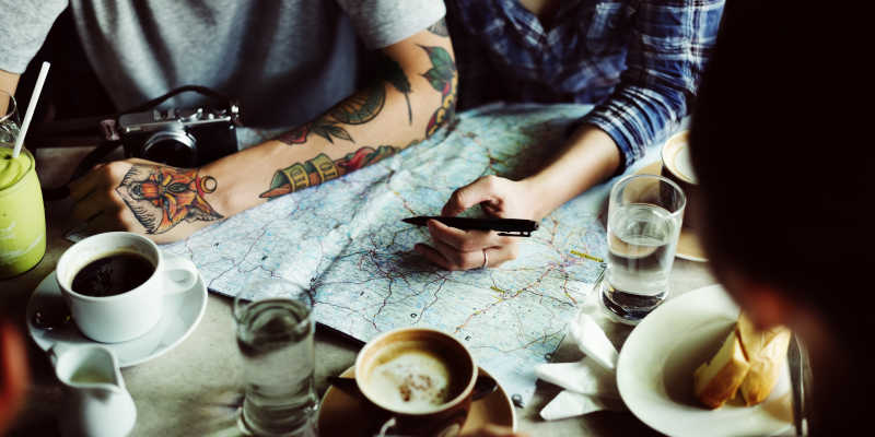 和朋友在桌子上的地图预定旅游地点