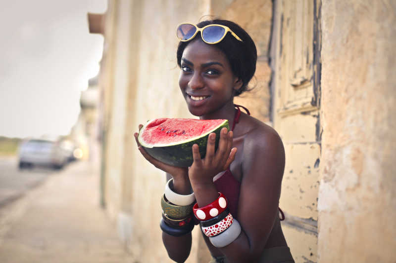 非洲女人拿着一片西瓜