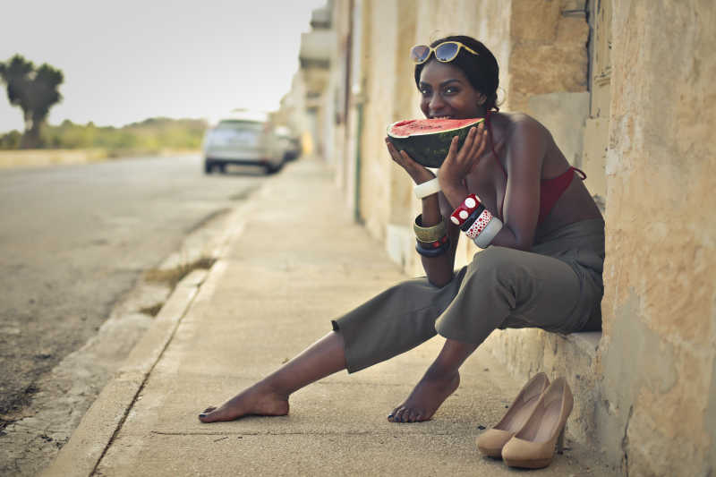 坐在街边正在吃西瓜的性感黑人美女