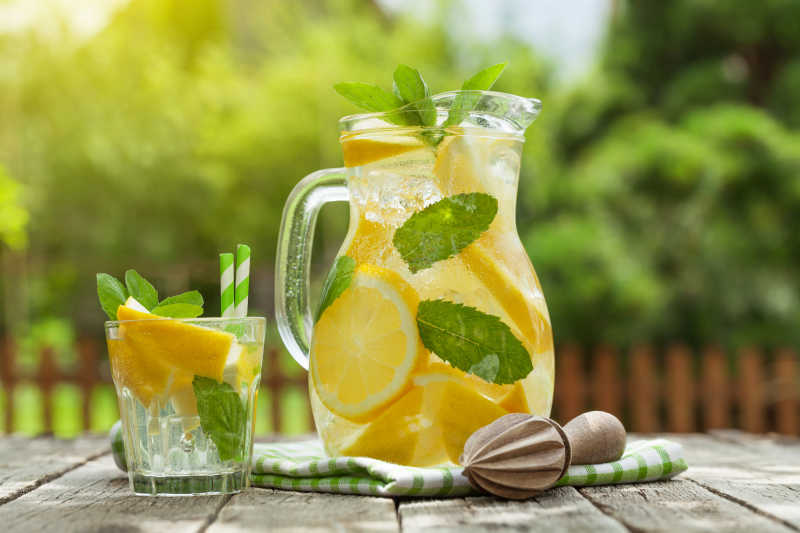 花园桌上柠檬汁罐和玻璃杯