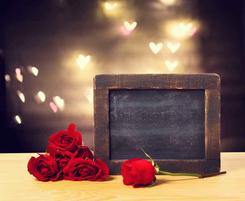 红色玫瑰和空白黑板