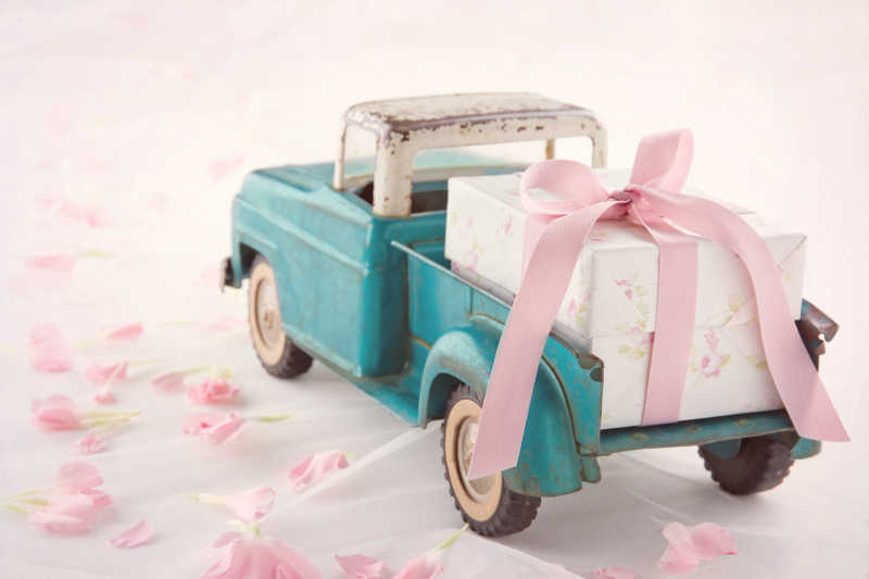 带粉红色缎带礼品盒的古董玩具车