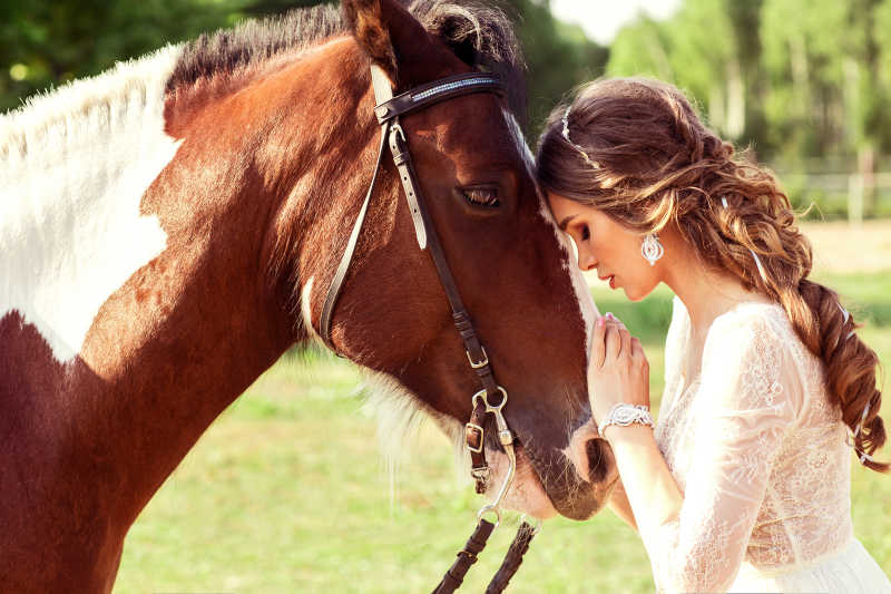 头靠头的年轻美女与马匹