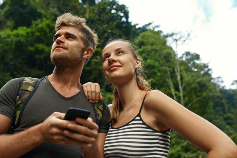年轻夫妇享受夏季热带森林的旅游