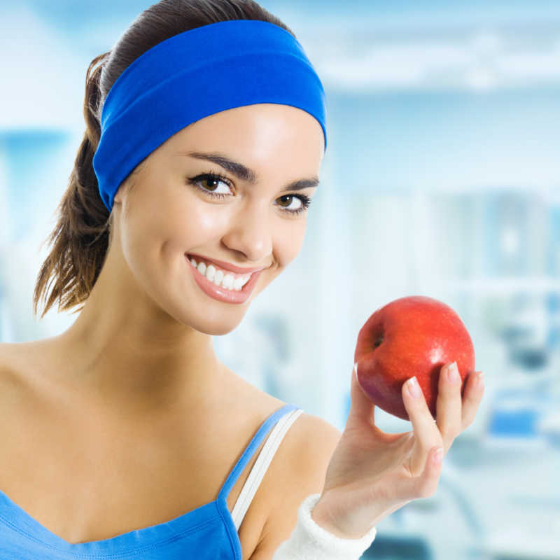 穿运动装的女人拿着苹果