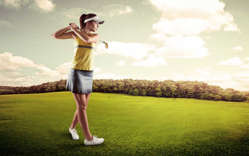 在绿色草地上打高尔夫球的女人