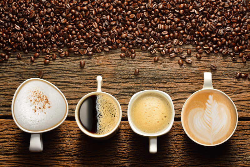 木桌上的四种口味的咖啡与咖啡豆