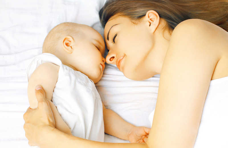 睡在床上的小宝宝和母亲