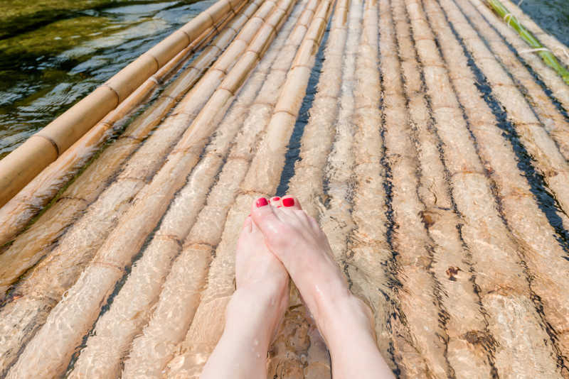 水上漂流竹筏上的女人的脚