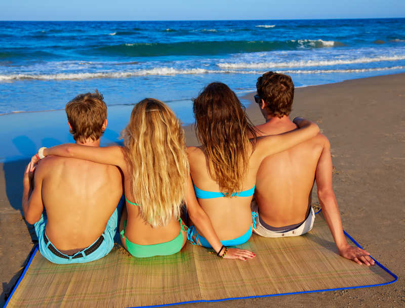 海滩上度假的情侣朋友后视图