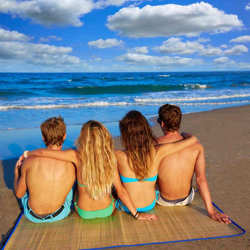 朋友沙滩情侣坐在沙滩度假