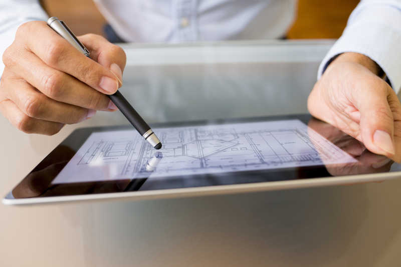 男性用手笔在电脑上设计平面图