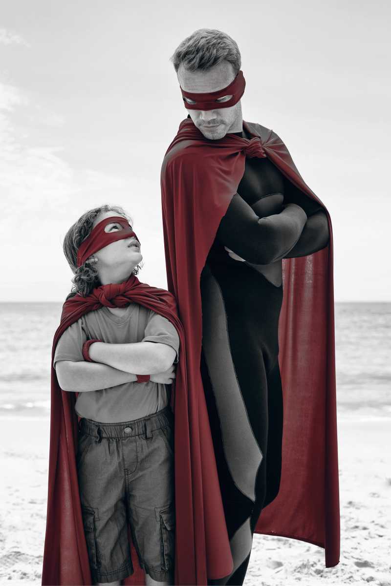 海滩上穿着超人服饰的父子