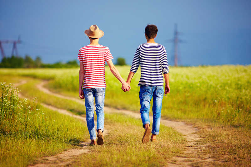 手牵手走在夏野路上的同性情侣