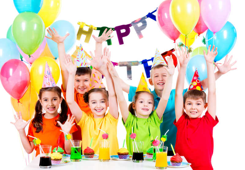 一群快乐的孩子在生日聚会上举手欢呼
