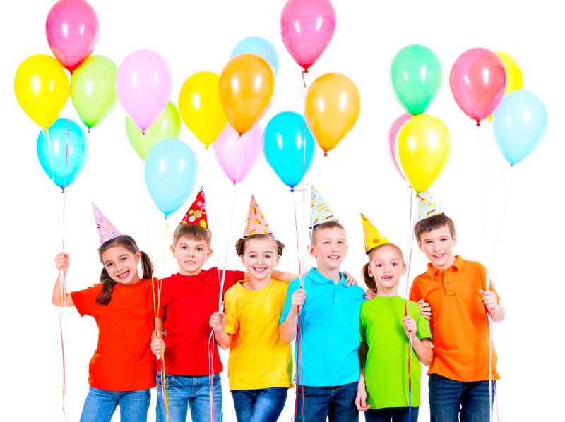 一群穿着彩色T恤和戴着派对帽的微笑孩子们